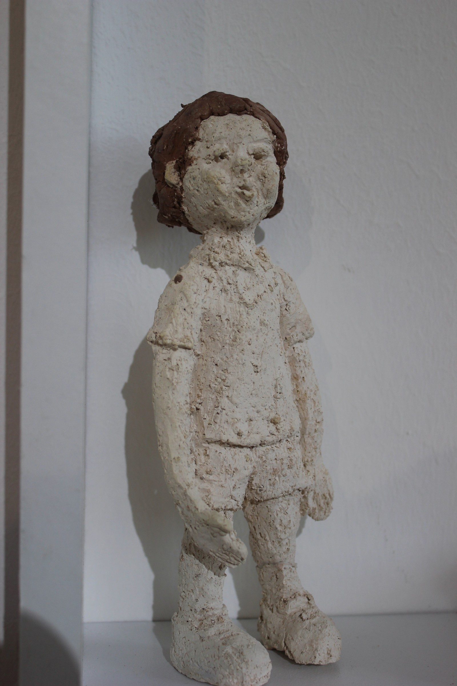 Niño de cerámica de pie