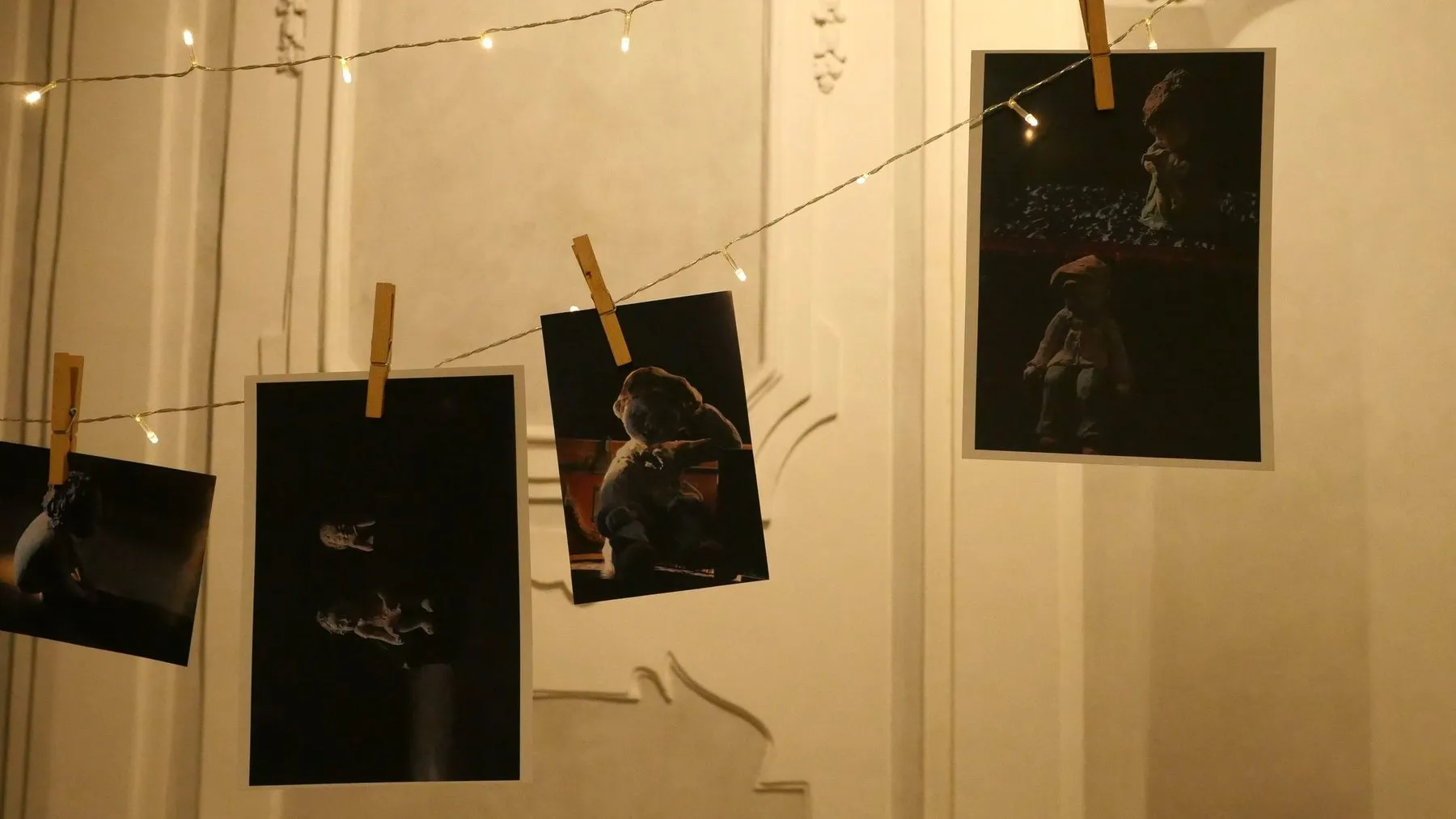 Photographs of the sculptures hung with pegs from a string of lights